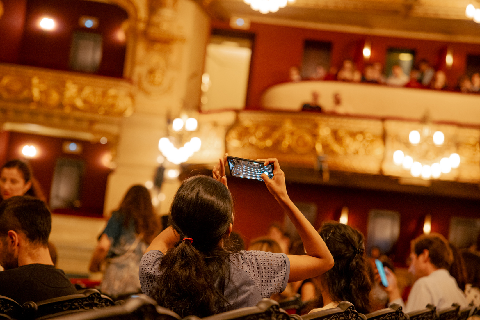 Espectadora fent una fotografia amb el mòbil a la sala del Gran Teatre del Liceu abans de la funció.
